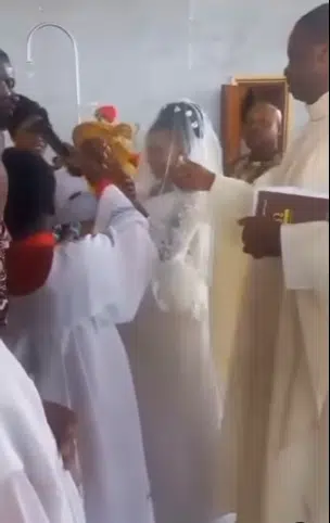 Moment priest gives altar boy 'heavy' knock for not keeping microphone steady during wedding 