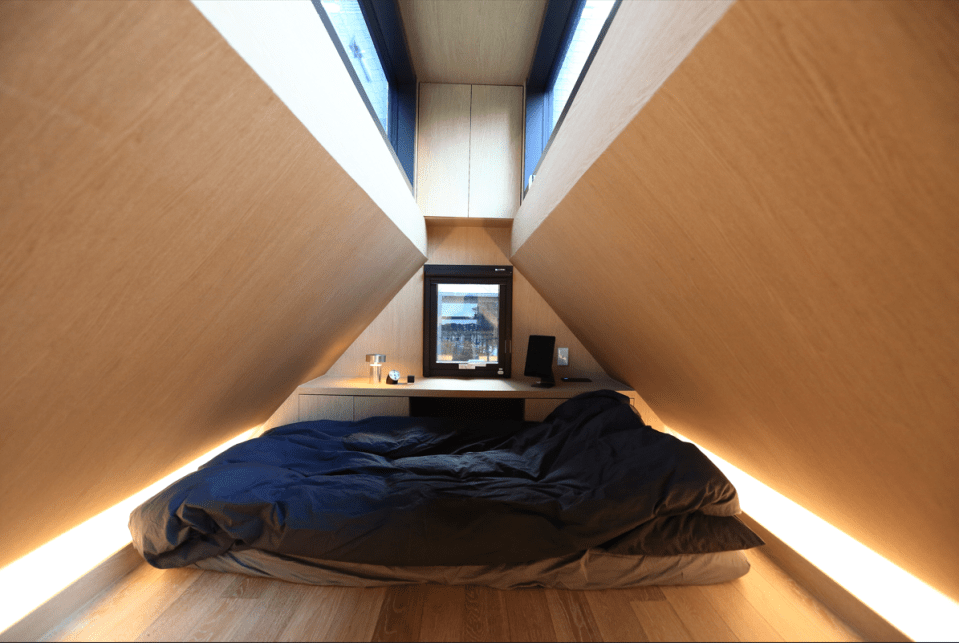 Tucked away in the roof is the bedroom, with an a-frame style slanted ceiling