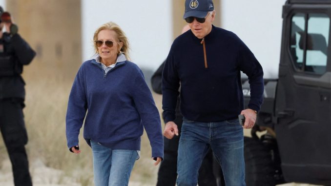 Moment Joe Biden wobbles and stumbles on sandy beach as Jill struggles to keep him up during day out in Delaware