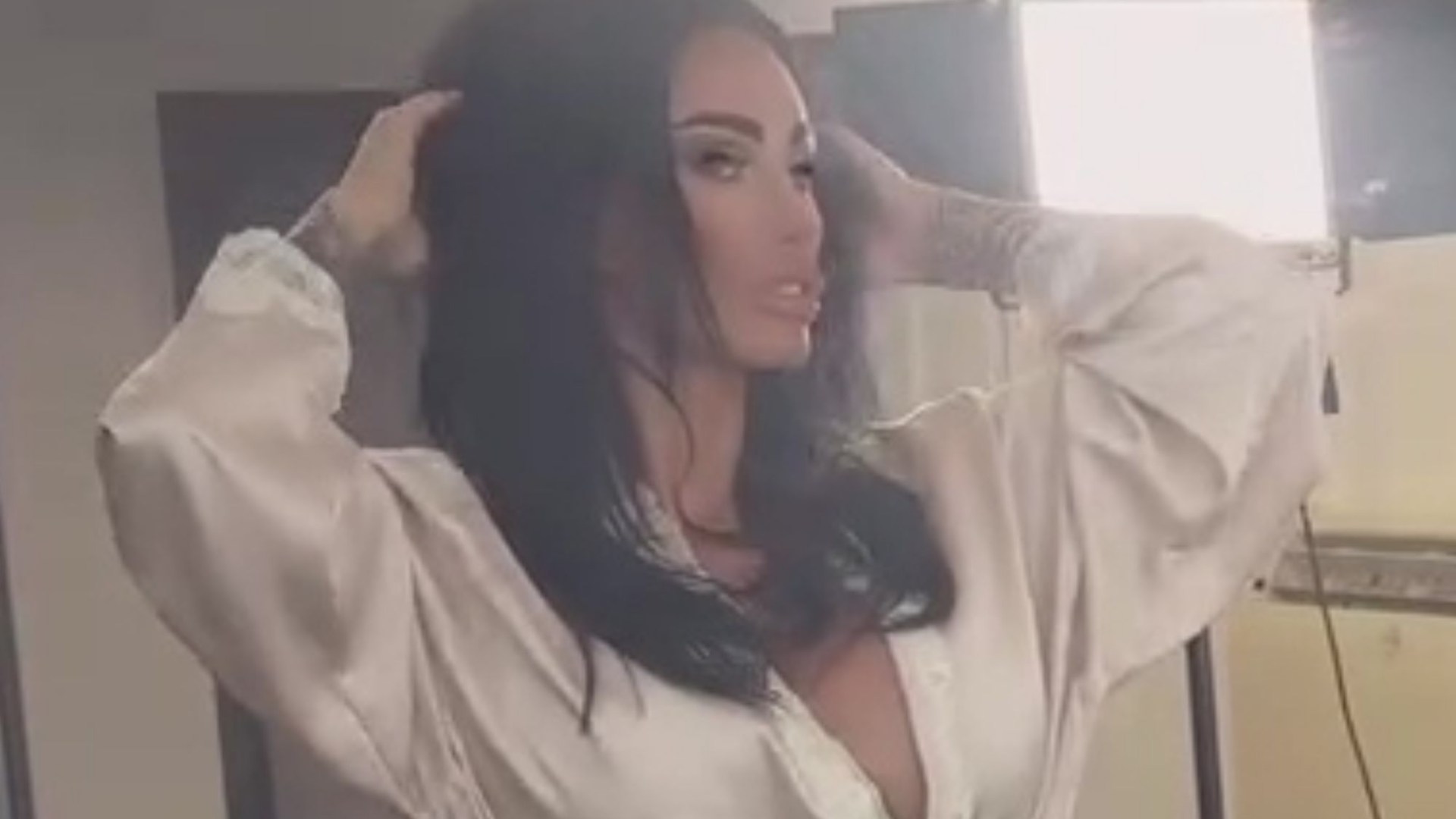 Katie Price risks slipping out of silk plunging gown as she poses up a storm at a photoshoot