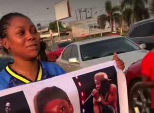 Lady goes viral for carrying banner of Rema on the street to prove her love